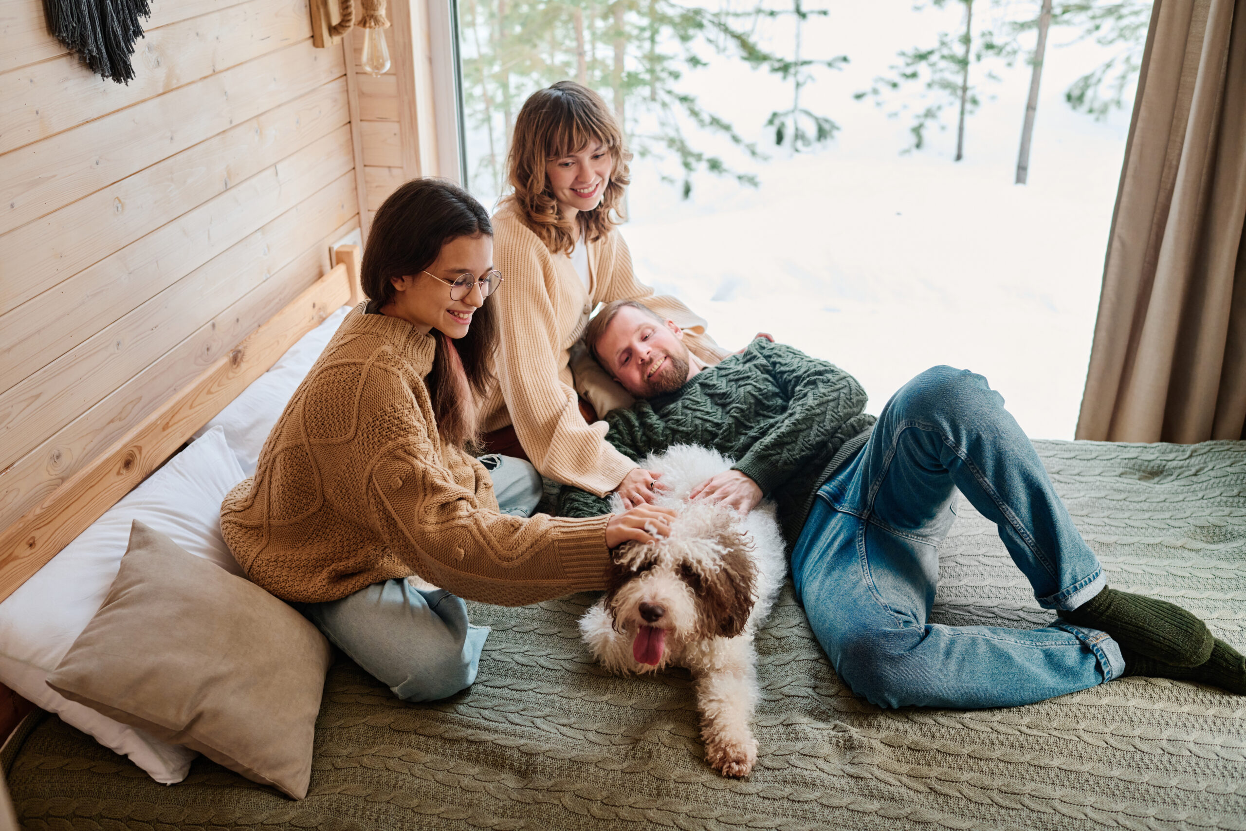 Image shows a happy family laying inside a warm and cozy home that has been winterized - they are cozy and content